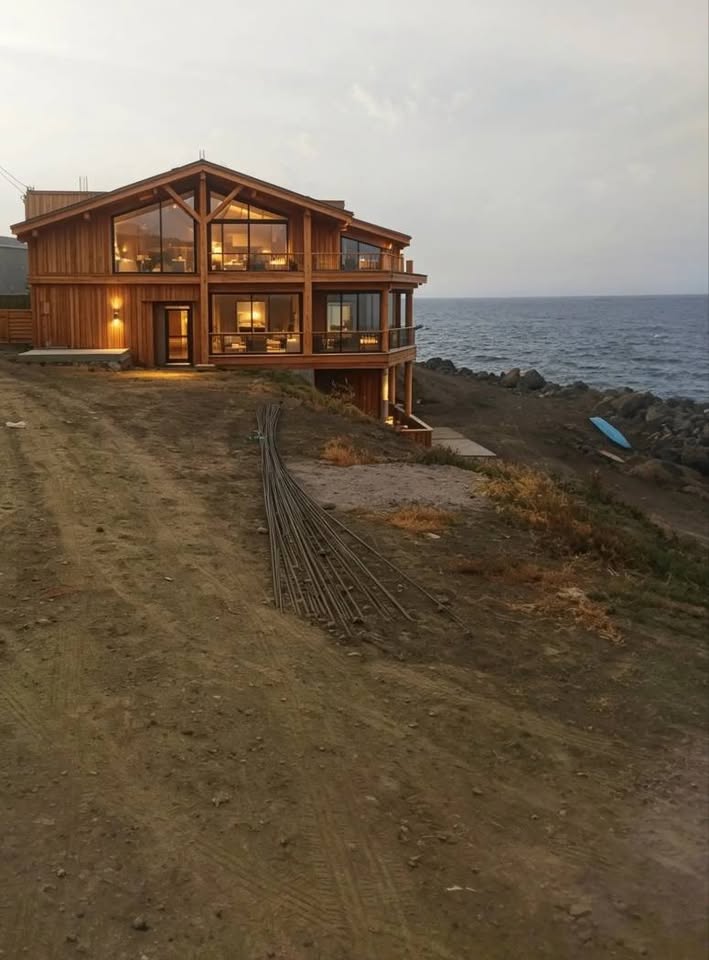 Grand chalet classique en bois et métal au bord de la mer